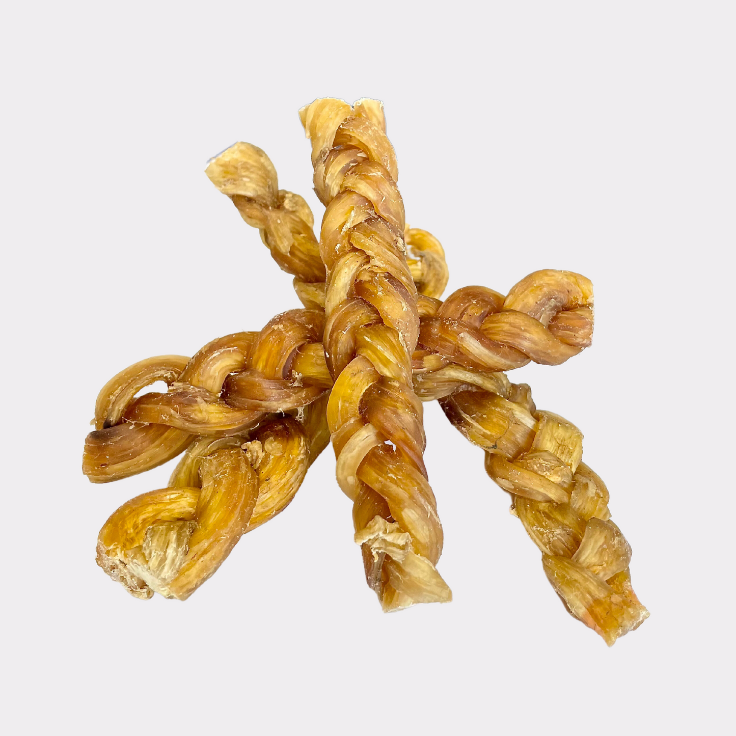 Four braided lamb skin natural dog treats intertwined on an all white background.