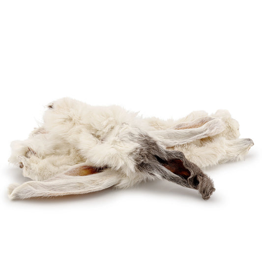 A stack of white hairy rabbit ears on an all white background.