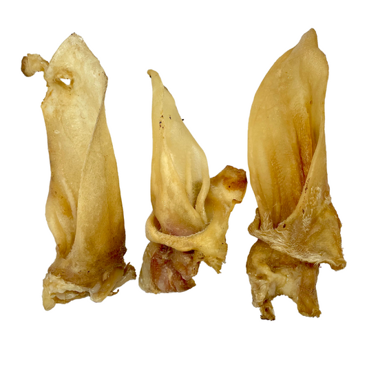 Three plain lamb ears natural dog treats laid side by side on an all white background.