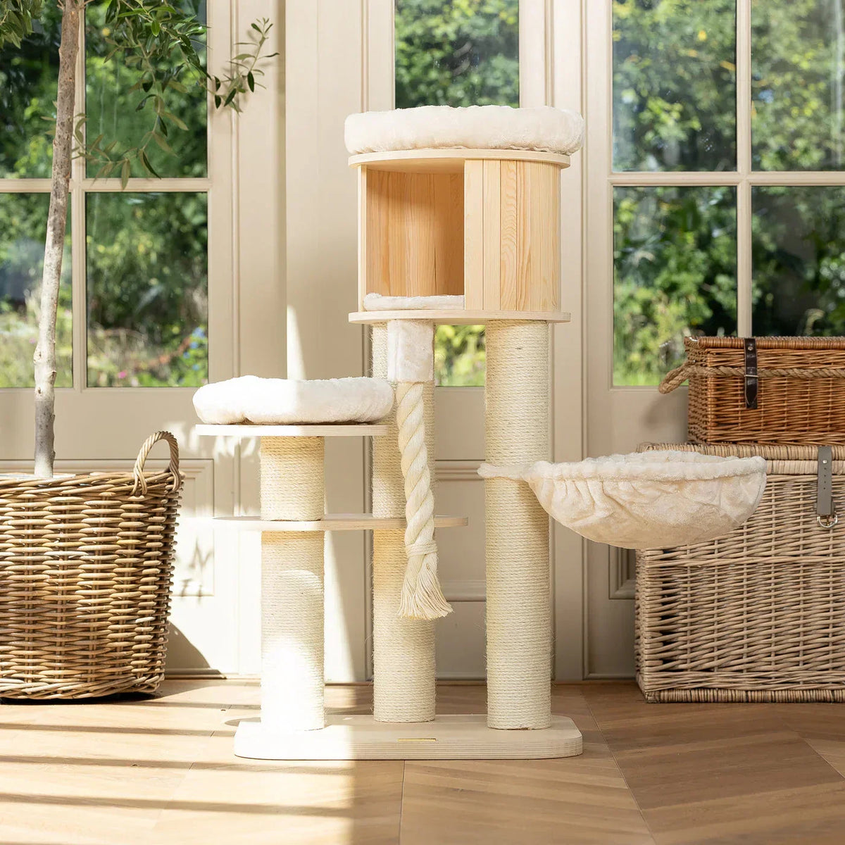 Lords & Labradors Helsinki Loft cat tree with platforms, hammock, and hideaway beside large window in living room