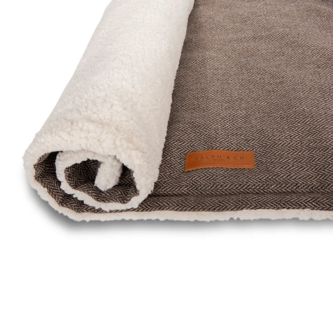 Close-up of the Ralph & Co logo on a dog blanket with soft sherpa reverse lining