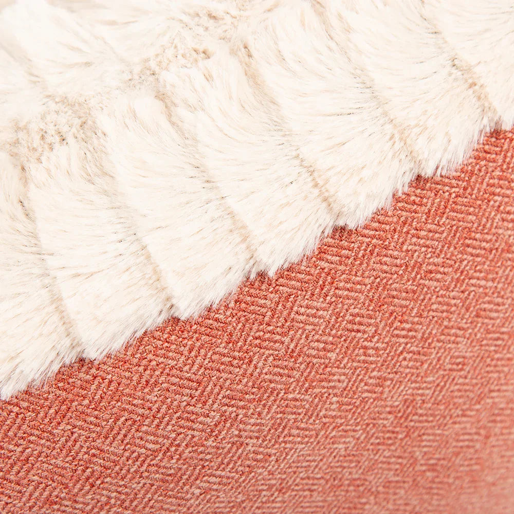 Close-up of terracotta red tweed fabric and cream plush trim.