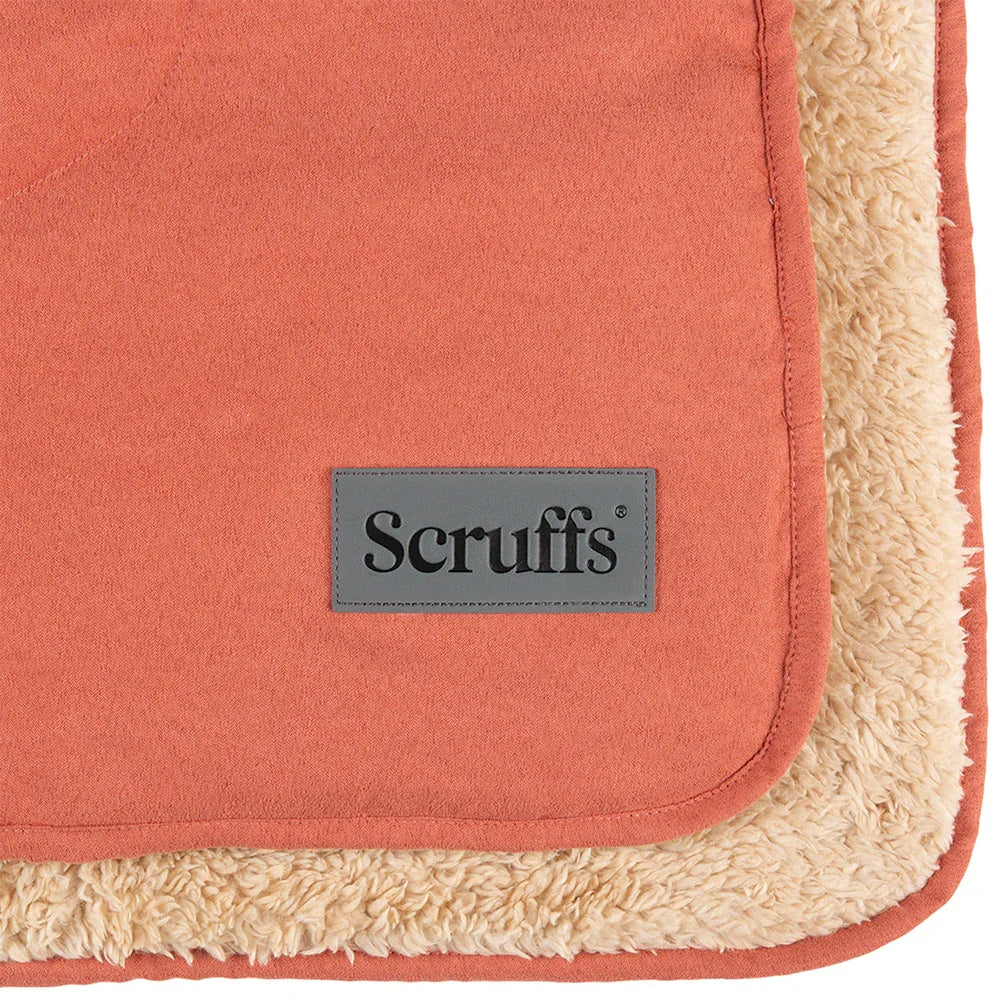 Close-up of the Scruffs logo on a terracotta dog blanket with sherpa lining